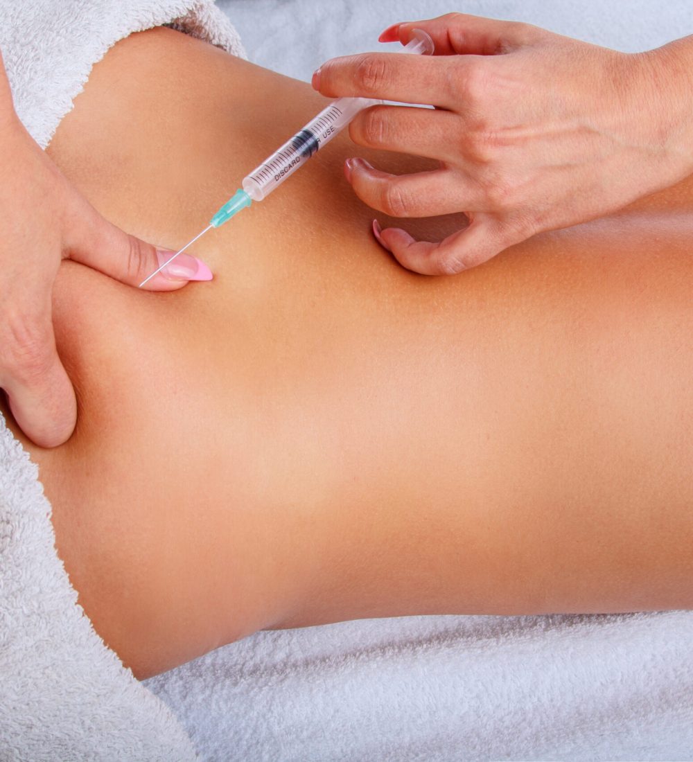 Syringe injection in to woman’s back. Syringe injection in to woman's back. Female enjoing relaxing back massage in cosmetology spa centre.